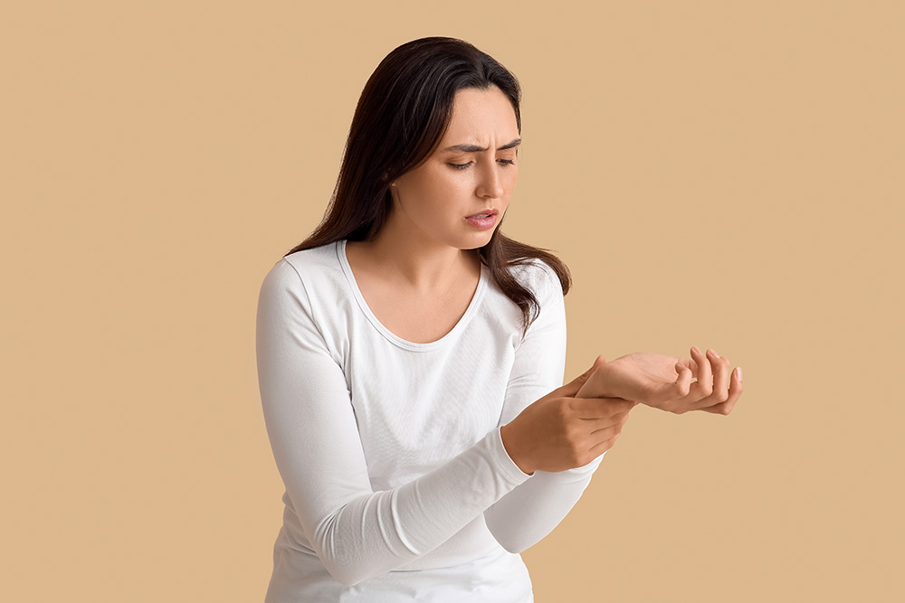 Young adult woman with rheumatoid arthritis experiences joint pain in her fingers.